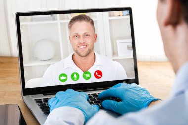 Coronavirüs Karantinasındaki Eldivenli Adam doktorla görüntülü görüşme yapıyor.