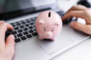Pembe Piggybank ile Laptop Üzerinde Çalışan İşadamı Nın Eli Close-up