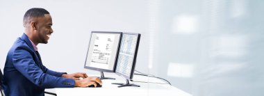 İş yerindeki bilgisayardan faturayı kontrol eden bir iş adamının yan görüntüsü