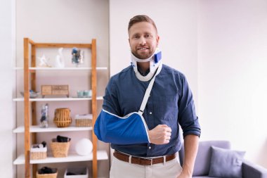 Kırık elli ve kırbaçlı bir adam evinde acı çekiyor.