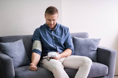 Evde kan basıncını ölçen bir adam var. Kronik Hastalık