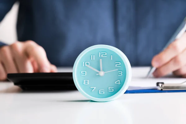 Businessperson Using Calculator Calculating Bill Alarm Clock Desk — Stock Photo, Image