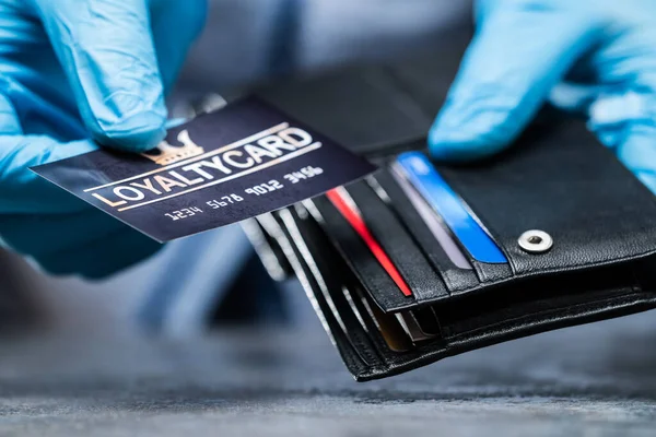 stock image Consumer Taking Loyalty Card From Wallet In Gloves To Protect From Coronavirus