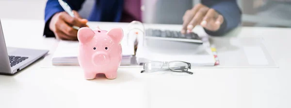 Banner Pink Piggybank Frente Empresarios Calculando Impuestos —  Fotos de Stock