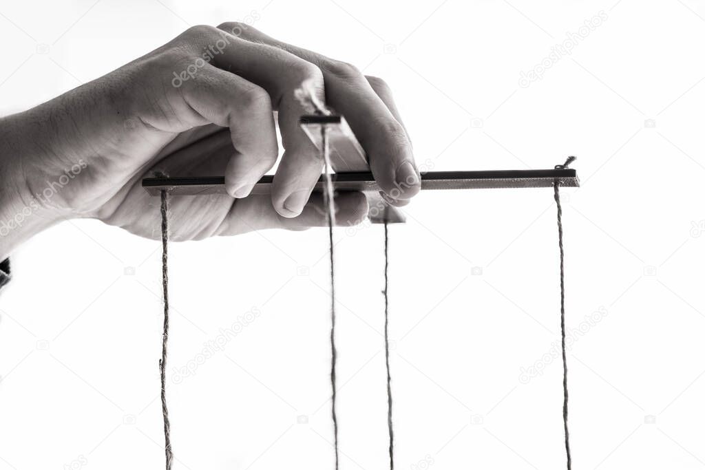 Close-up Of A Person's Hand Manipulating Marionette With String On Gray Background