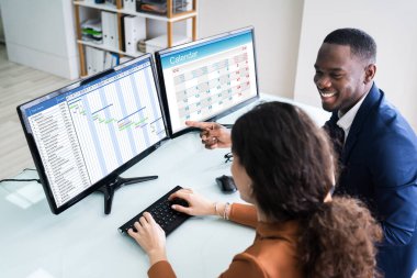 Gantt Çizelgesini Analiz Eden Genç İş Adamları ve Ofisteki Bilgisayarda Takvim