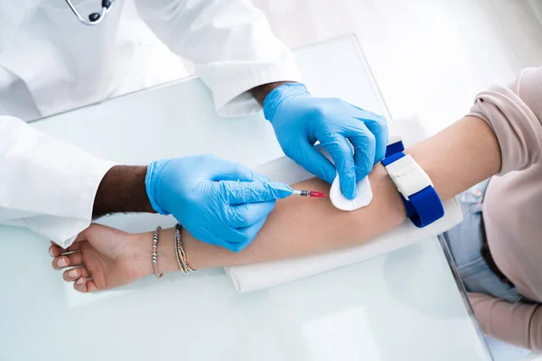 クローズ アップの女性医師が男性患者の血液サンプルを収集するために注射器を注入 — ストック写真