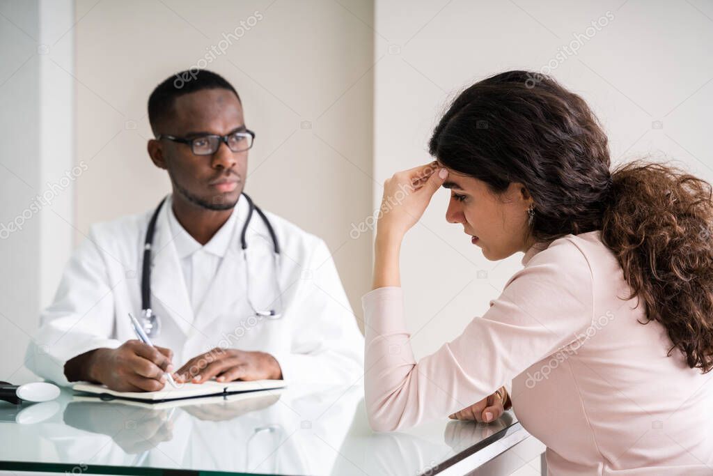 Doctor Discussing With Female Patient In Clinic