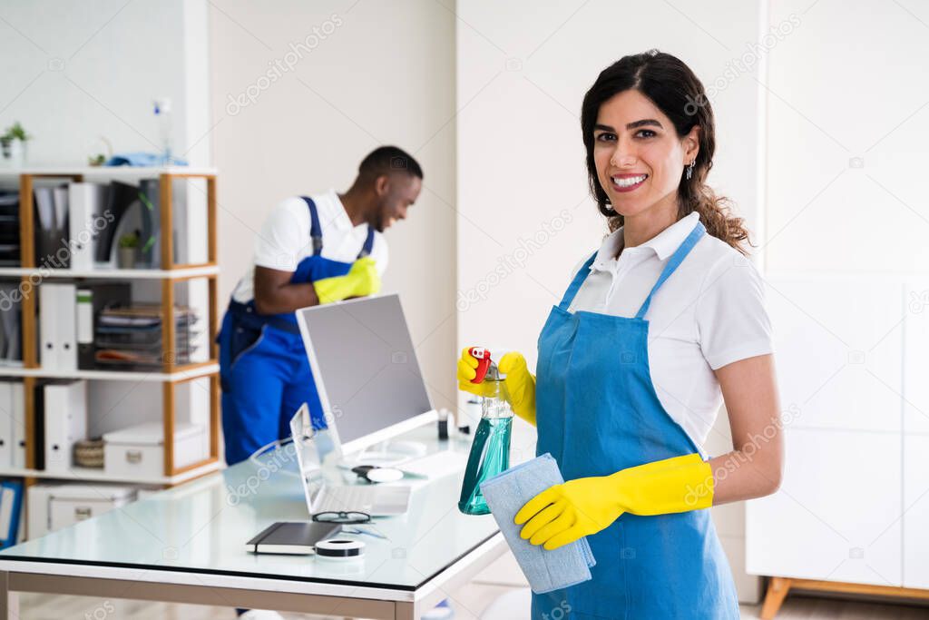 Portrait Of A Happy Female Janitor With Cleaning Equipment In Office