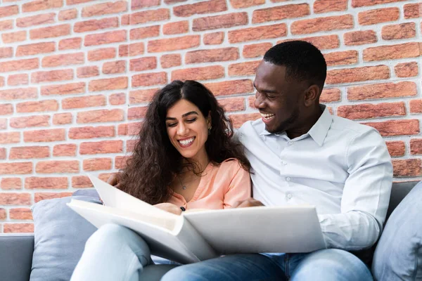 High Angle View Couple Sitting Sofa Looking Photo Album — Stock Photo, Image