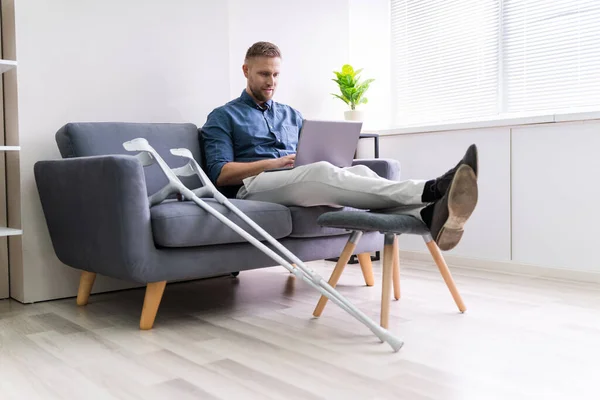 Homem Com Lesão Perna Sentado Sofá Usando Laptop — Fotografia de Stock