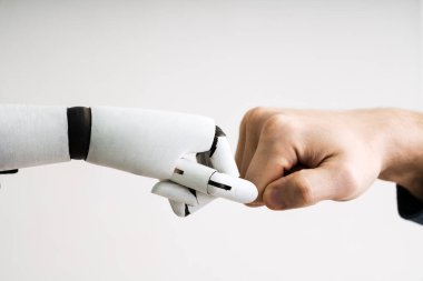Robot ve insan eli yumruk çarpmak gri arka plan üzerinde yapma