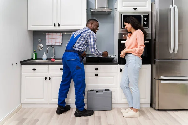 Vrouw Kijken Naar Militair Uniform Vaststelling Van Inductie Fornuis Keuken — Stockfoto