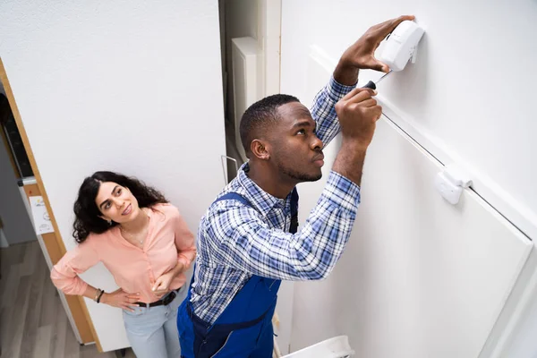 Mujer Feliz Mirando Electricista Instalando Detector Movimiento Del Sistema Seguridad — Foto de Stock