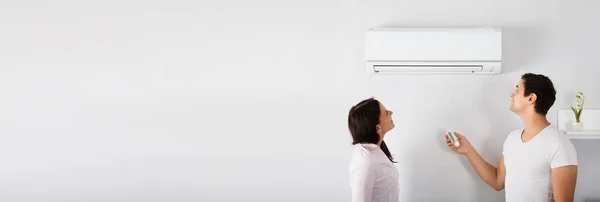 Paar Betreibt Klimaanlage Wohnzimmer Hause — Stockfoto