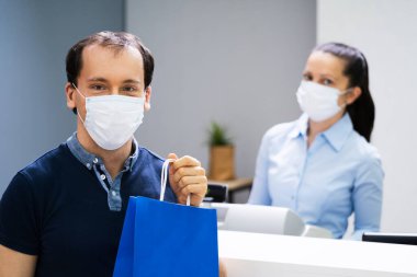 Perakende dükkanındaki kasiyer ya da kasiyer maske takıyor
