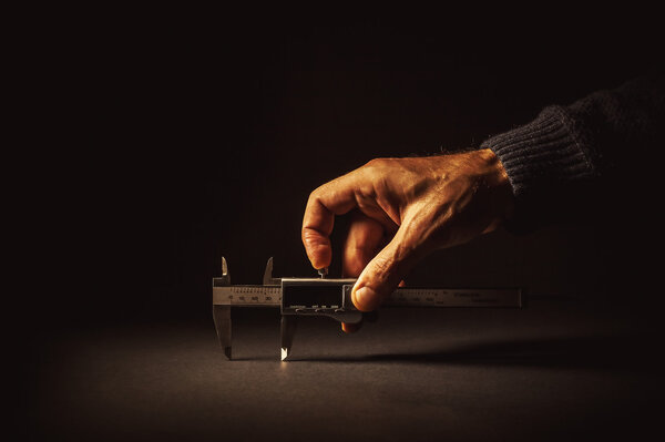 Male Hand Holding a Vernier Caliper 