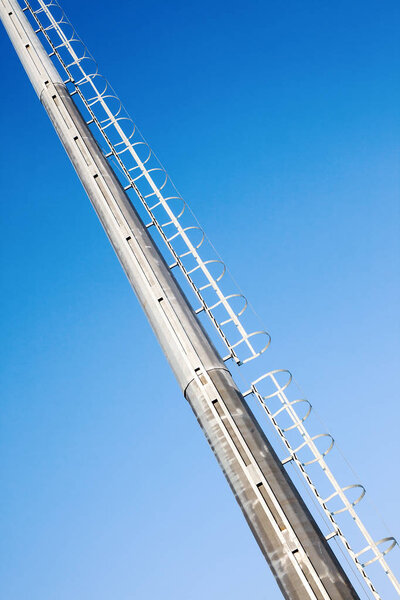 Details of big metal ladders, blue sky in background.