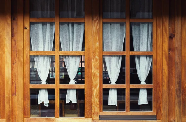 Decoratieve houten ramen en gordijnen — Stockfoto