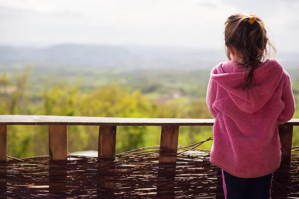 Jeune fille devant la clôture — Photo