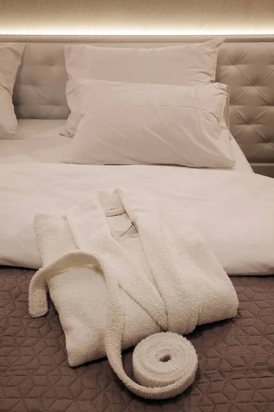 Albornoz nuevo blanco en la cama — Foto de Stock