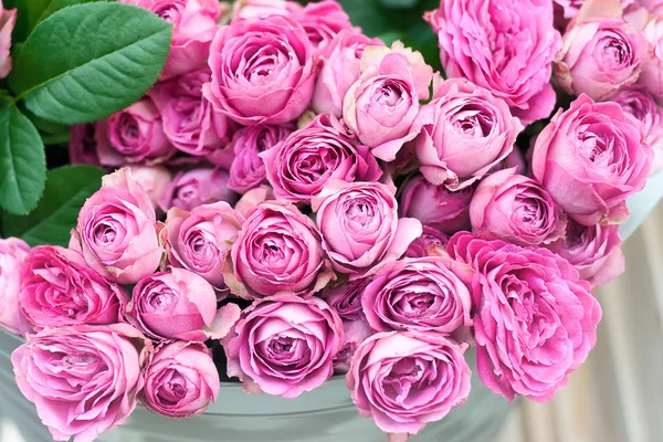 Beautiful pink roses in bucket on street flower market. Pink roses flowers holiday background.