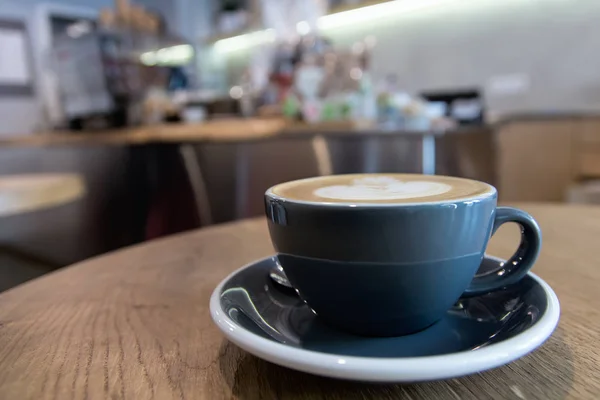 Caffè Cappuccino Una Tazza Blu Tavolo Legno Con Moderno Coffeeshop — Foto Stock