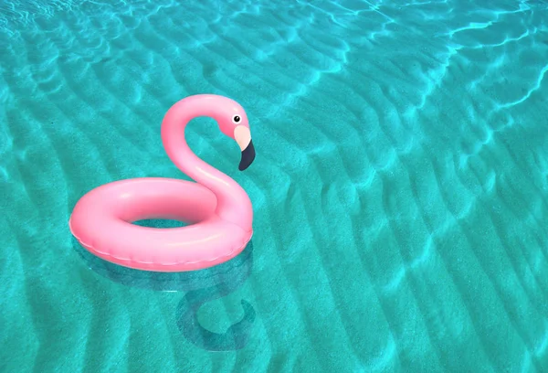 Надувний рожевий фламінго плаває на поверхні моря — стокове фото