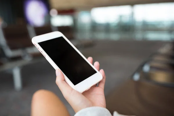 Женщина, использующая мобильный телефон в аэропорту — стоковое фото