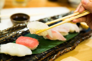 Sofrada yemek çubukları olan bir suşi.