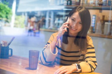 Kadın kafe içinde cep telefonu üzerinde söz