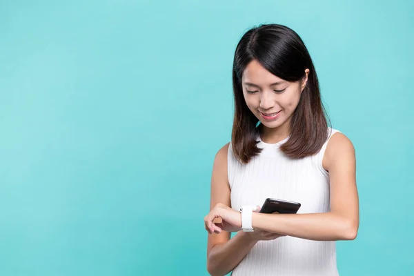 Vrouw verbinden cellphone met slimme horloge — Stockfoto