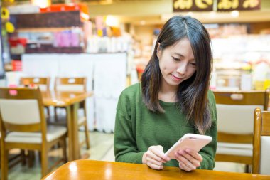 Japon lokantasında cep telefonu kullanan kadın 