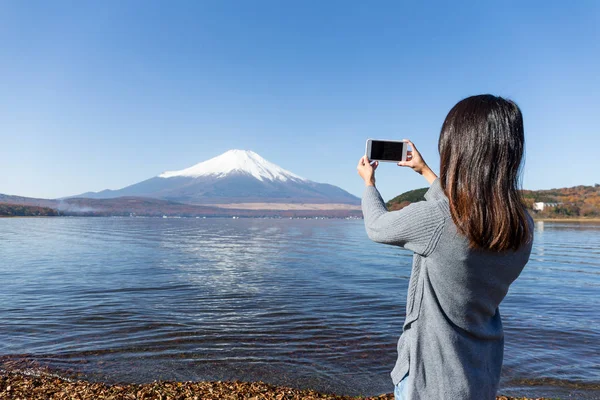 Kobieta zrobić zdjęcie za pomocą telefonu komórkowego z Mount Fuji — Zdjęcie stockowe