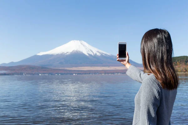 Mujer usando el teléfono móvil para tomar fotos en Fujisan —  Fotos de Stock