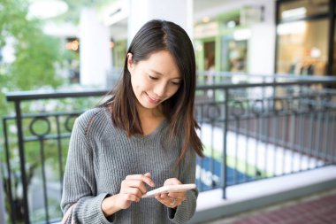 Alışveriş merkezinde cep telefonu kullanan kadın