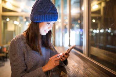 Geceleri cep telefonu kullanan kadın