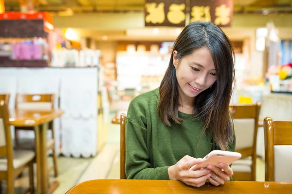 Женщина с мобильным телефоном в японском ресторане — стоковое фото