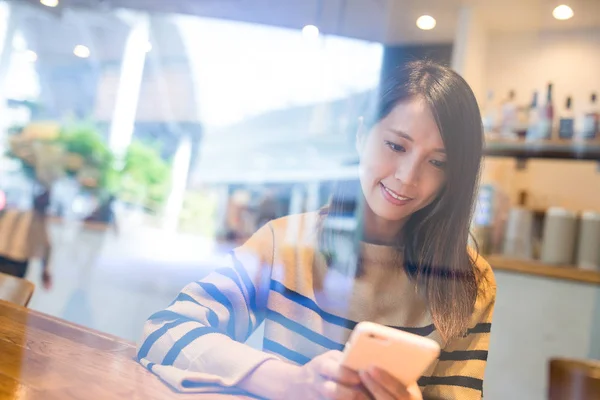 Mulher usando celular dentro da cafeteria — Fotografia de Stock