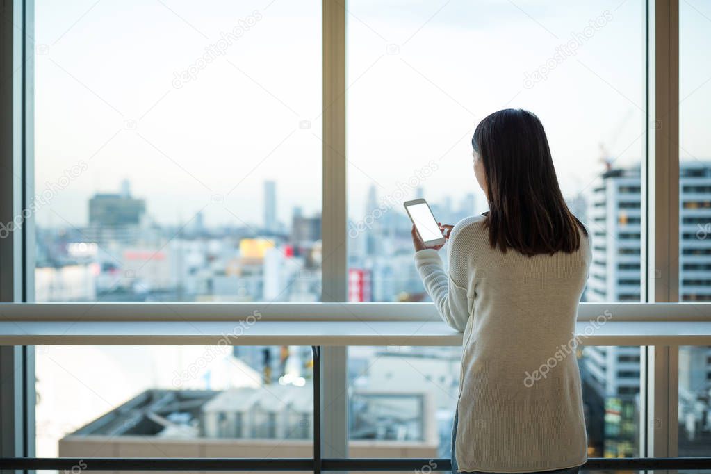 Woman using cellphone inside office