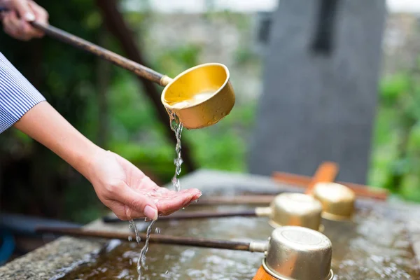 Femme utilisant la louche de bambou d'eau pour la purification — Photo