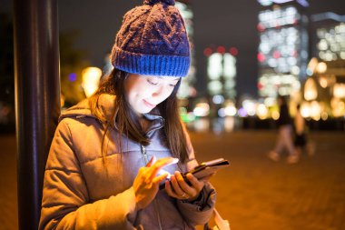 cep telefonuyla şehirde gece kadın