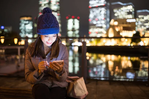 Geceleri cep telefonu kullanan bir kadın. 