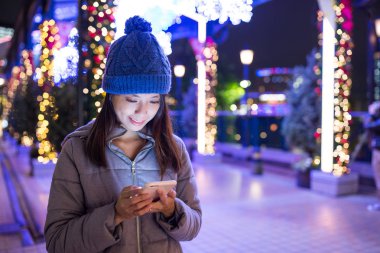 Geceleri cep telefonu kullanan bir kadın.