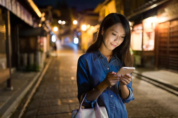 Mujer usando el teléfono móvil por la noche —  Fotos de Stock