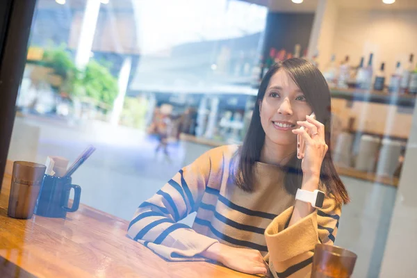 Kadın konuşmak için hareket eden telefon içinde Restoran