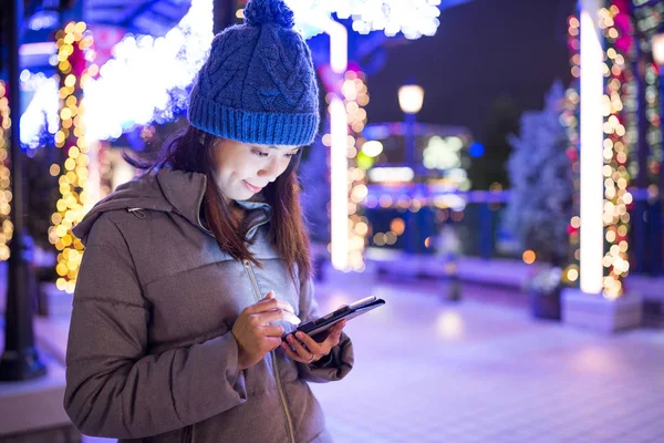 Geceleri cep telefonu kullanan bir kadın.