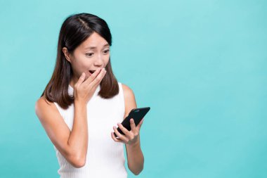 Kadın cep telefonunda şok edici şeyler okuyor.