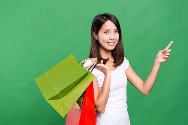 Femme tenant des sacs à provisions et doigt pointant vers le haut — Photo