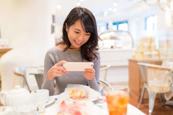 Woman taking photo in cake shop — Stock Photo, Image